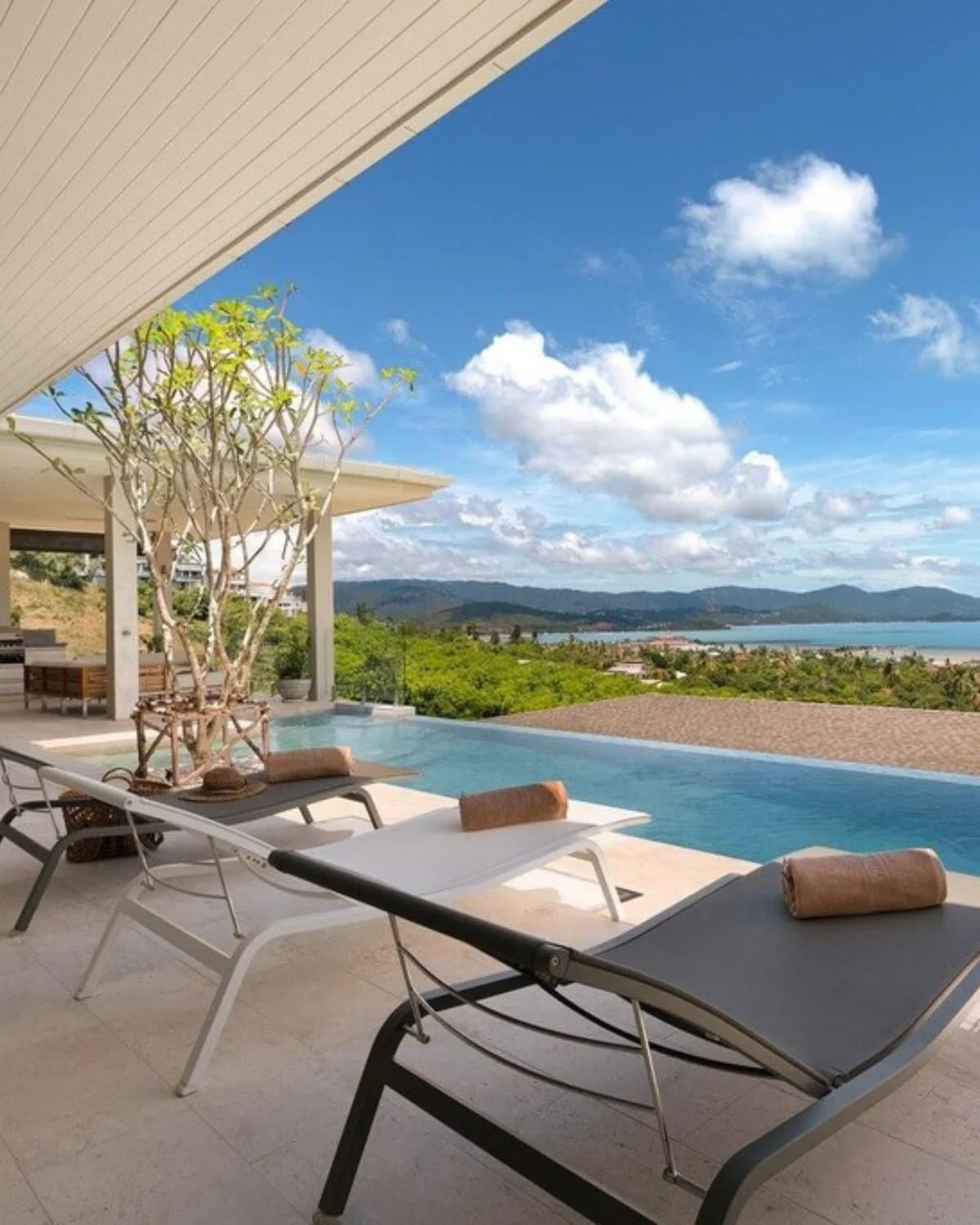 Piscine à débordement avec transats et vue mer sur Koh Samui en plein jour