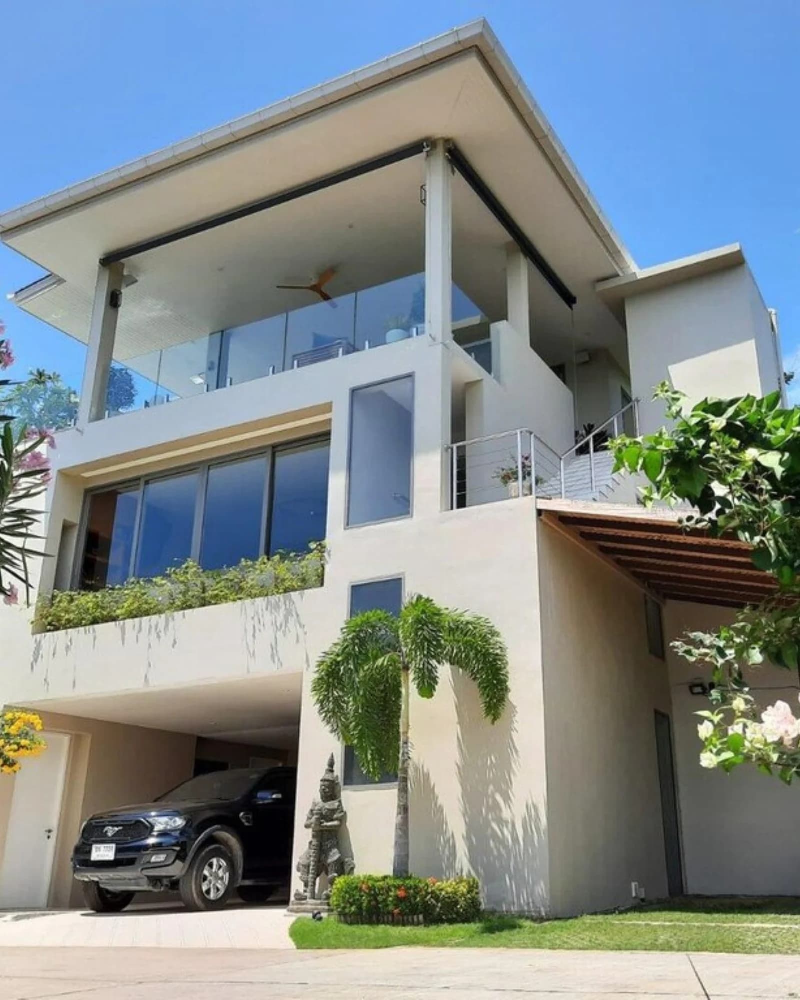 Façade extérieure d'une villa privée moderne à Koh Samui, architecture contemporaine et palmiers